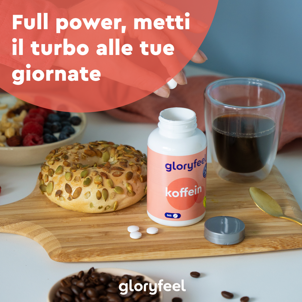 Un bagel, caffè e bacche sono appoggiati su una tavola di legno con una bottiglia di gloryfeel Italia Caffeina e pillole. Il testo sopra recita: &quot;Piena potenza, metti il turbo alle tue giornate.