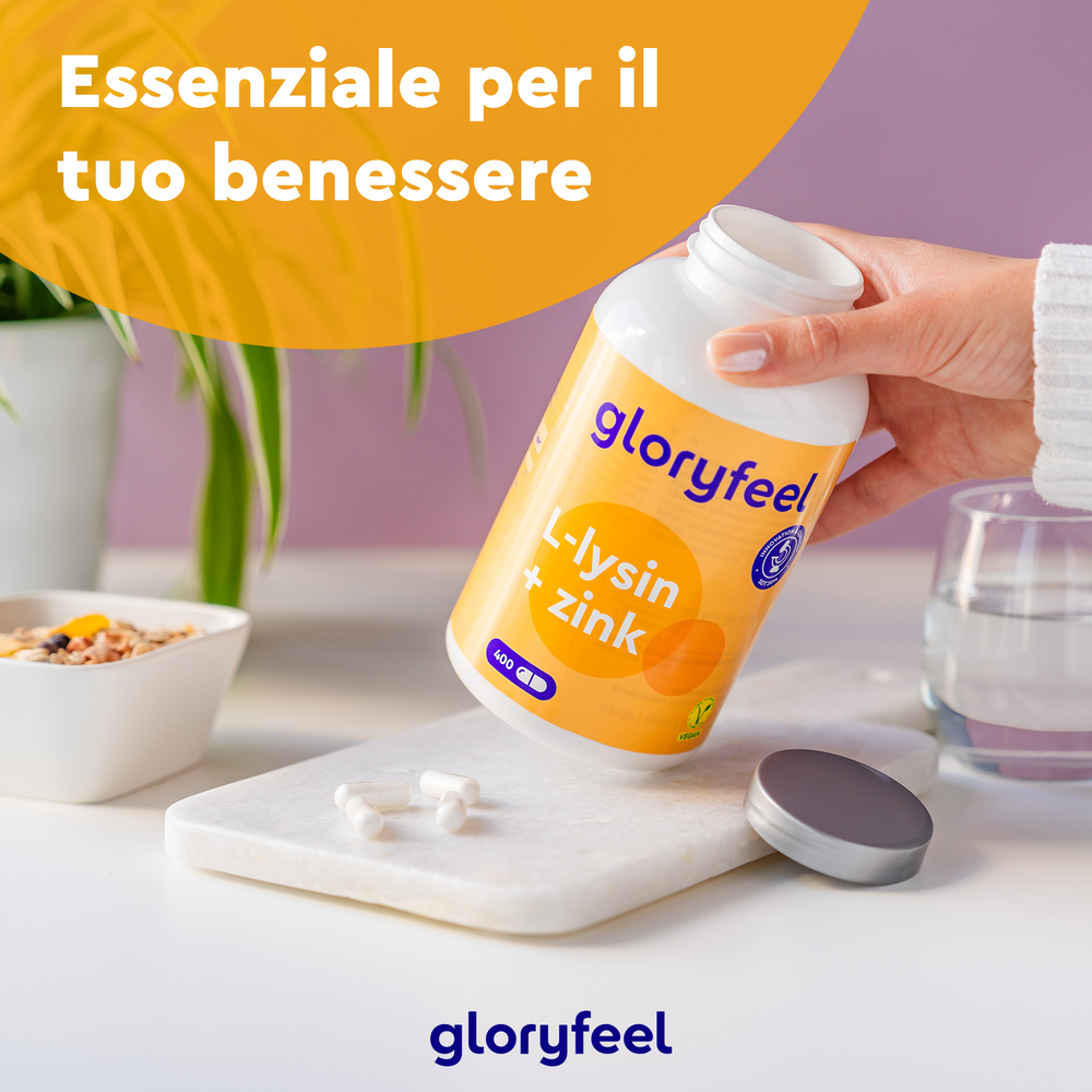 Una mano tiene una bottiglia di &quot;GloryFeel GmbH Italy&quot; L-Lisina + zinco, essenziale per il benessere. Le capsule sono adagiate su una superficie bianca vicino a un bicchiere e una pianta. Il testo in italiano recita &quot;Essenziale per il tuo benessere&quot;, sottolineando il loro beneficio per il sistema immunitario.
