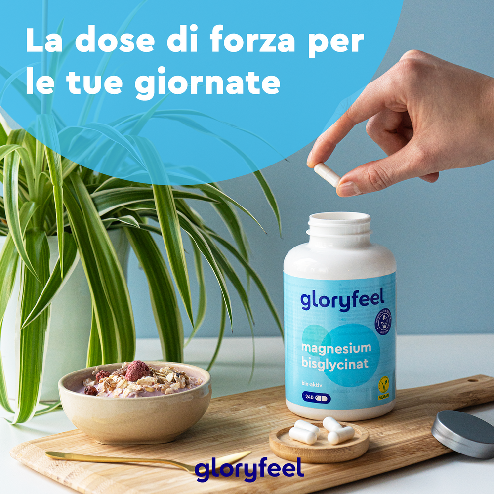 Mano che tiene due capsule su una bottiglia aperta di Bisglicinato di magnesio su un tavolo con una ciotola di cereali. Il testo italiano sull&