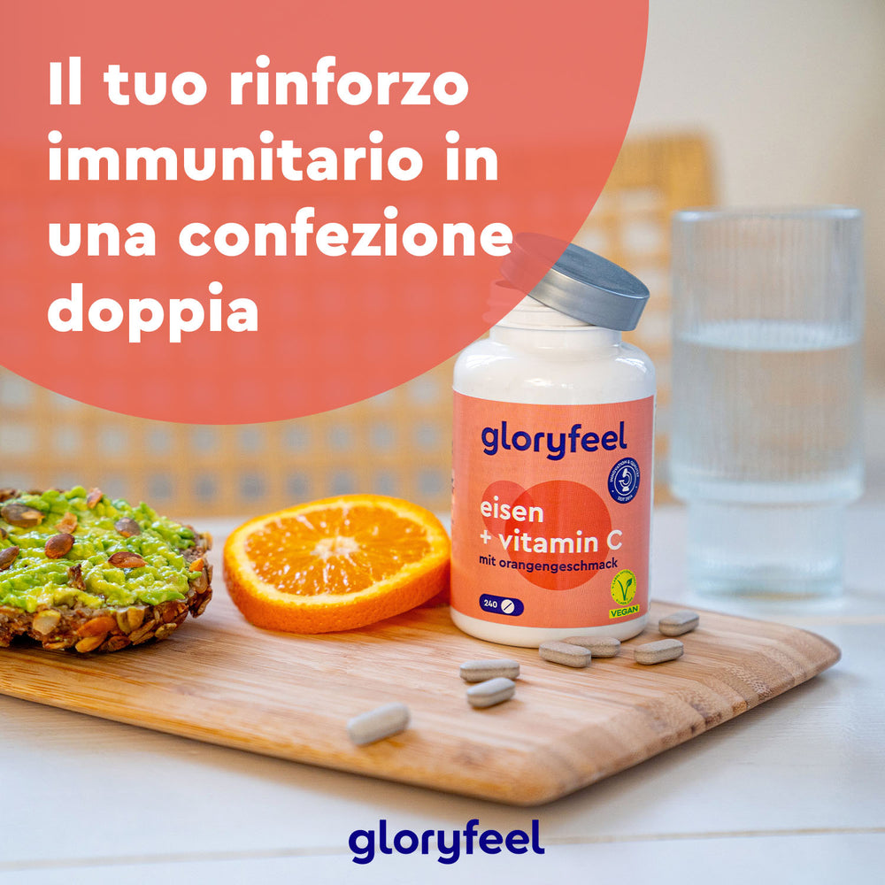 Una bottiglia di Ferro con Vitamina C della GloryFeel GmbH Italia è appoggiata su un tagliere accanto a una fetta d&