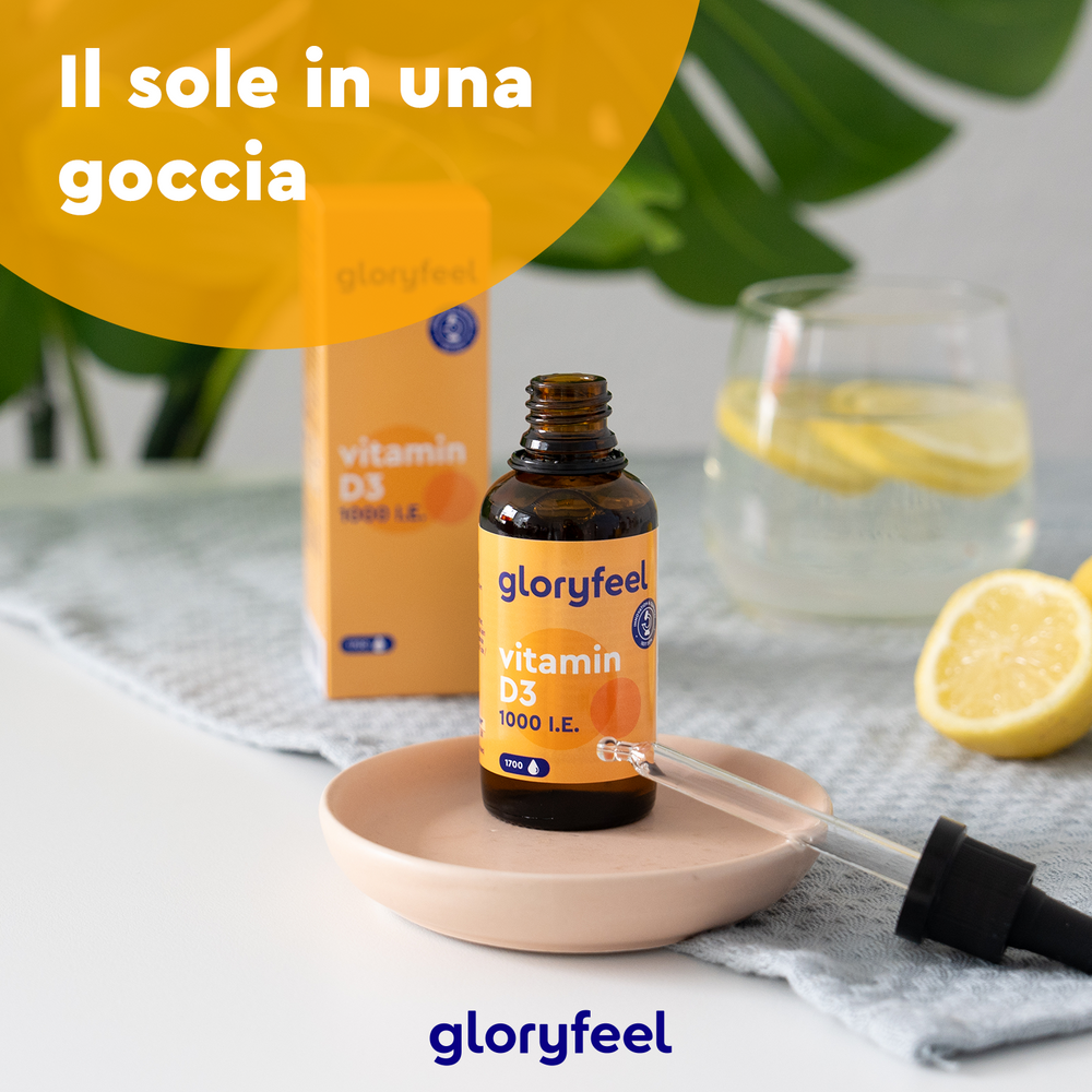 Un piatto contiene una bottiglia di Vitamina D3 in Gocce con un contagocce, accanto a una scatola, un limone tagliato e un bicchiere d&