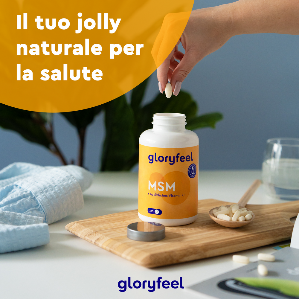 Una mano afferra una bottiglia di Zolfo MSM con vitamina C della GloryFeel GmbH Italia su una tavola di legno, circondata da capsule rovesciate; il testo in italiano sottolinea i benefici per la salute.