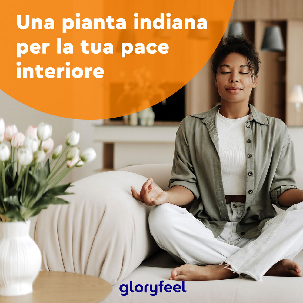 Una persona medita su un divano, con gli occhi chiusi, con un arredamento per la casa che mostra un vaso di tulipani. Il testo in italiano adorna l&