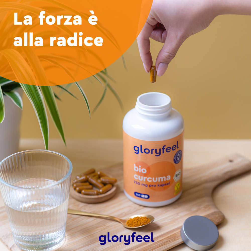 Una mano afferra una capsula di curcuma biologica da una bottiglia &quot;Bio Curcuma&quot; di GloryFeel GmbH Italy su un tavolo di legno. Nelle vicinanze, c&
