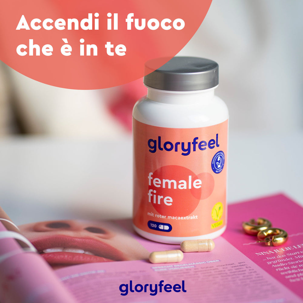 La bottiglia &quot;Maca Rossa in capsule Female Fire&quot; di GloryFeel GmbH Italia è appoggiata su un tavolo insieme alle capsule e a una rivista aperta.