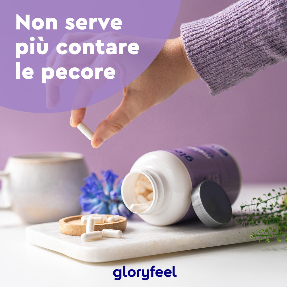 Una persona prende una capsula da un flacone aperto di Melatonina + L-triptofano della GloryFeel GmbH Italia, con una tazza, un fiore blu e del testo in italiano nelle vicinanze.