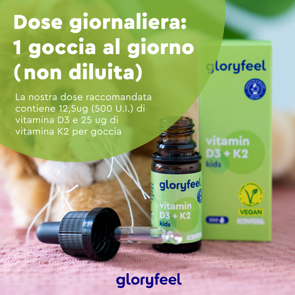Una bottiglia e una scatola di Vitamina D3 K2 Gocce Kids di gloryfeel Italia sono appoggiate su una superficie. Il testo in italiano specifica la dose giornaliera come una goccia, non diluita, sottolineando il contenuto di vitamine per il sistema immunitario. Un&